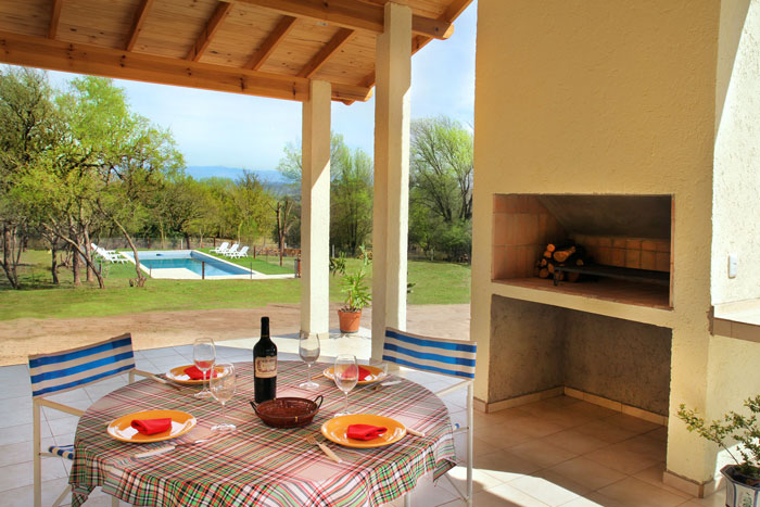 Vista a la piscina desde la galería con asador